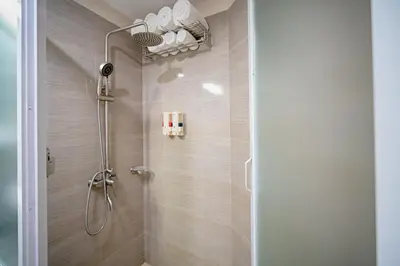 a shower with a shower head in a bathroom at Achievers Airport Hotel in Manila