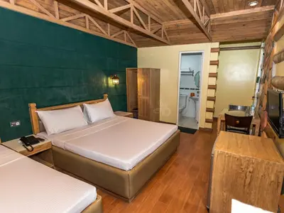 a bedroom with two beds and a green wall at Urban Travellers Hotel in Manila