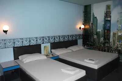 two beds in a room with a city skyline at Urban Travellers Hotel in Manila