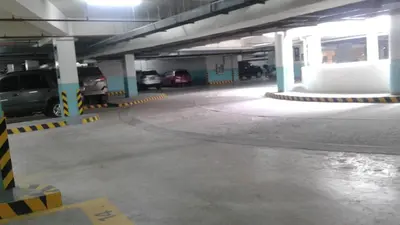 an empty parking garage with cars parked in it at One Palm Tree Apartments in Manila