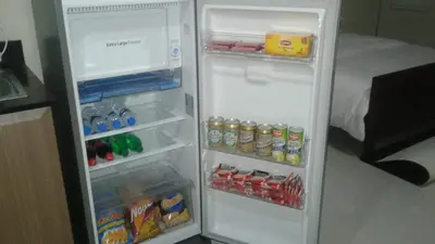 an open refrigerator filled with drinks and drinks at One Palm Tree Apartments in Manila