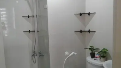 a bathroom with a shower with a toilet and a sink at One Palm Tree Apartments in Manila