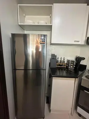 a stainless steel refrigerator in a small kitchen at Suites de Marina Manila with Netflix in Manila