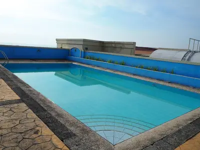 a swimming pool with blue tiles on a building at Suites de Marina Manila with Netflix in Manila