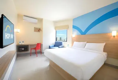 a hotel room with a large bed and a desk at Hop Inn Hotel Aseana City Manila in Manila