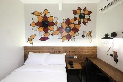 a bedroom with a bed with flowers on the wall at U Hotels Makati in Manila