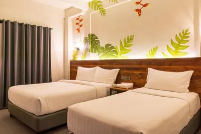 two beds in a hotel room with plants on the wall at U Hotels Makati in Manila