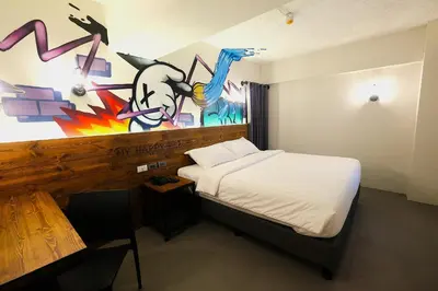 a bedroom with a bed and a painting on the wall at U Hotels Makati in Manila
