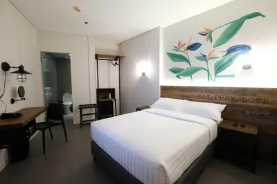 a bedroom with a bed and a desk and a painting at U Hotels Makati in Manila