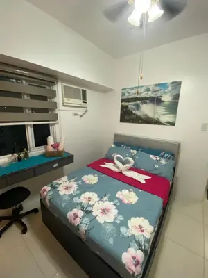 a bedroom with a bed with a desk and a bed sidx sidx sidx at Your HOME @ Princeton Residences, New Manila in Manila