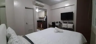 a bedroom with a white bed and a flat screen tv at 150 Newport City Condo - near NAIA T3 AIRPORT MANILA in Manila