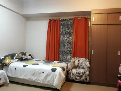 a bedroom with a bed and a chair and curtains at 150 Newport City Condo - near NAIA T3 AIRPORT MANILA in Manila