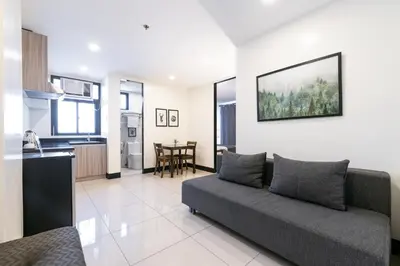 a living room with a couch and a kitchen at Artemis Place Makati Hotel in Manila