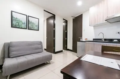 a living room with a couch and a kitchen at Artemis Place Makati Hotel in Manila