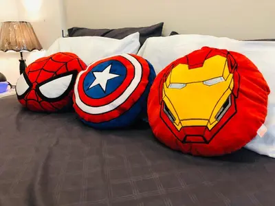 three superhero pillows on top of a bed at Pine Crest Condominium in Manila