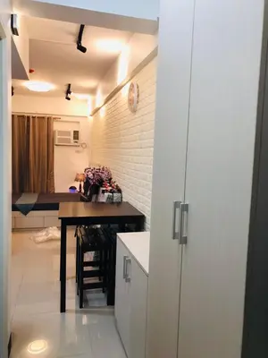 a kitchen with a counter and a table in a room at Pine Crest Condominium in Manila