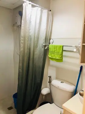a bathroom with a shower curtain and a toilet at Pine Crest Condominium in Manila