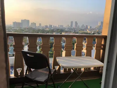 a table and chairs on a balcony with a view of the city at Pine Crest Condominium in Manila