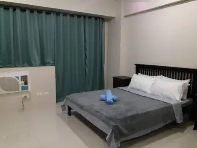a bedroom with a bed with a blue toy on it at One Palm Tree Villas in Manila