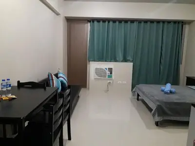 a hospital room with a bed and a table and chairs at One Palm Tree Villas in Manila
