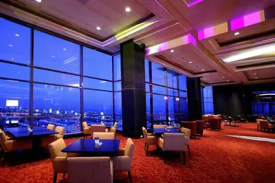 a restaurant with tables and chairs and a view of the city at The Bellevue Manila in Manila