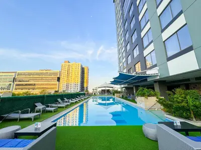a view of a hotel pool with chairs and buildings at The Bellevue Manila in Manila