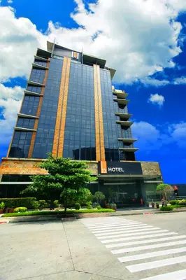 a hotel building with a tree in front of it at The B Hotel Alabang in Manila
