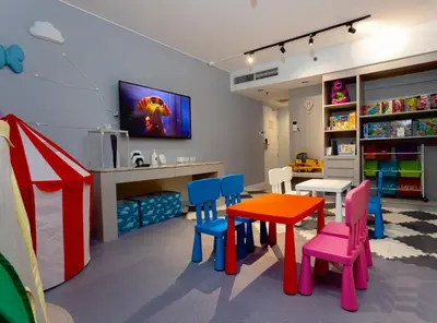 a room with a table and chairs and a tv at The B Hotel Alabang in Manila