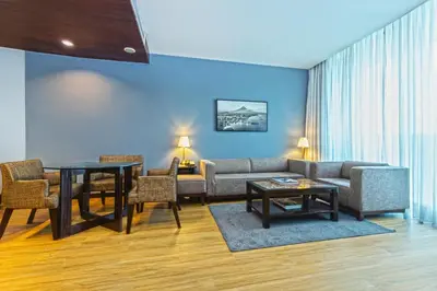 a living room with a couch and a table and chairs at The B Hotel Alabang in Manila