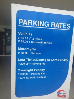 a sign for parking rates in a building at Shell Residences in Manila