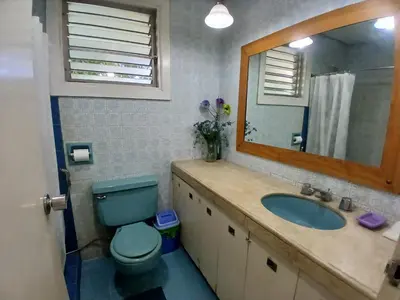 a bathroom with a blue toilet and a sink at Casa Joaquin BnB in Manila