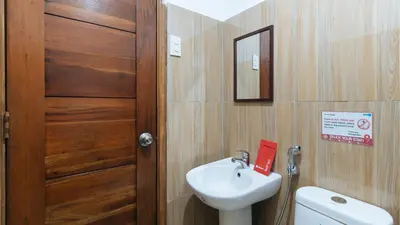 a bathroom with a sink and a toilet and a door at RedDoorz at DBuilders Rooms Ph1 Taguig in Manila