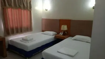 two beds in a hotel room with a window at Asia Novo Boutique Hotel - Rosario in Rosario