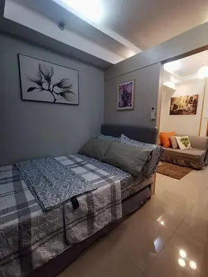 a bedroom with a large bed and a couch at Reese @ Sea Residences Manila in Manila