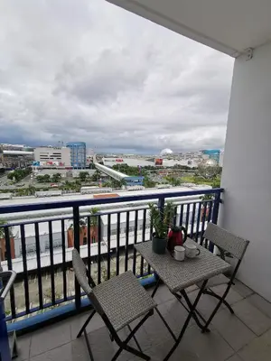 a balcony with two chairs and a table with a view at Reese @ Sea Residences Manila in Manila