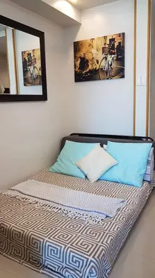 a bed with two pillows on it in a room at Reese @ Sea Residences Manila in Manila