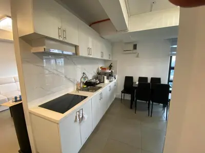 a kitchen with white cabinets and a table with chairs at Penthouse suite at Porto Vita Towers in Cubao Quezon City in Manila