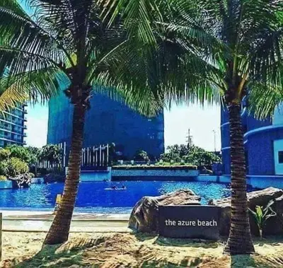 two palm trees in front of a swimming pool at Azure C7 Balcony, Wifi, Near Mall Airport in Manila