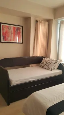 a bed in a room with a couch and a window at Condo Apartment near Manila Airport NAIA T3 in Manila