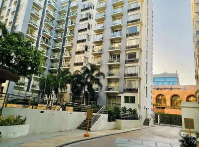 a large white building with palm trees in front of it at Condo Apartment near Manila Airport NAIA T3 in Manila