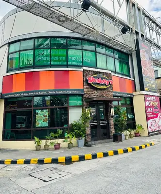 a building with a colorful facade with plants in front of it at DG Budget Hotel Salem in Manila