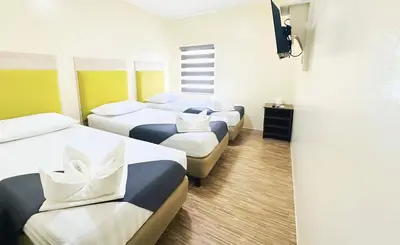 a hotel room with four beds and a television at DG Budget Hotel Salem in Manila