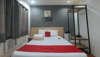 a bedroom with a large bed with a red blanket at RedDoorz Plus at Boni Avenue Mandaluyong in Manila