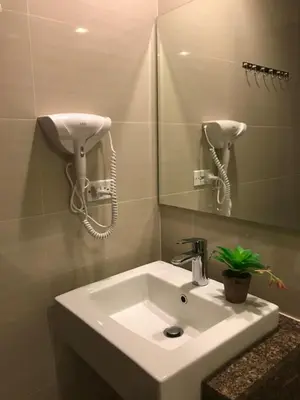 a bathroom with a sink and a phone on the wall at Travellers 101 Condo near Manila Airport in Manila