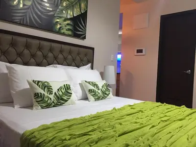 a bedroom with a large bed with green sheets and pillows at Travellers 101 Condo near Manila Airport in Manila