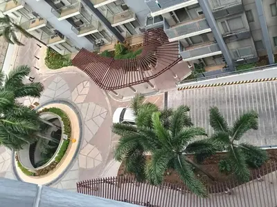 an overhead view of a building with palm trees and a train at Palm Tree Villas 1 in Manila