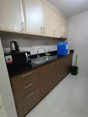 a kitchen with a sink and a microwave at Palm Tree Villas 1 in Manila