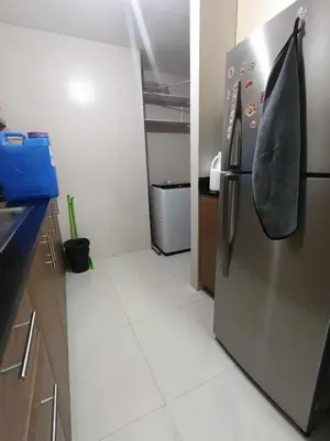 a kitchen with a stainless steel refrigerator with a shoe on it at Palm Tree Villas 1 in Manila