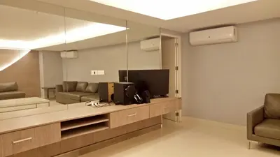 a living room with a television and two chairs at Jazz Residences Condo in Manila