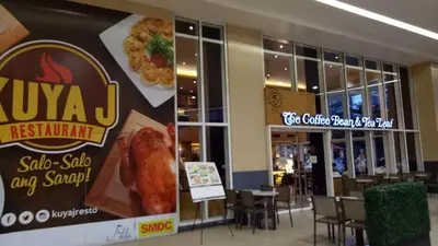 a restaurant with a sign on the wall and tables and chairs at Jazz Residences Condo in Manila